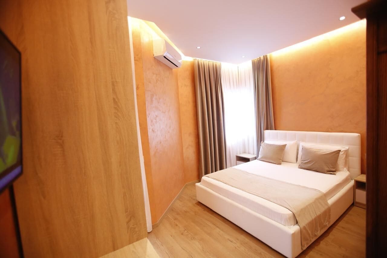 Une chambre d’hôtel moderne avec un grand lit, des murs en bois et un appareil de climatisation.