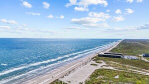 Vista sulla costa con spiaggia, una strada e degli edifici.