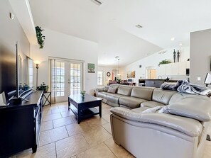 A modern living room with a sofa, a coffee table, and a TV. - 3BR Home Trailside Pool & Jacuzzi, Minutes from Inverness, Ocala & Crystal River (Inverness)