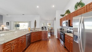 A modern kitchen with wooden cabinets, stainless steel appliances, and a granite countertop. - Villa S&G: Spacious 5 bedroom, family vacations (Inverness)