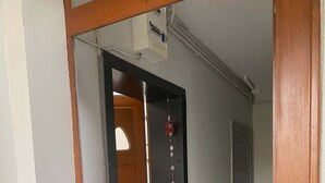 Ein Flur mit einem hölzernen Türrahmen, einer schwarzen Tür und einer weißen Wand.