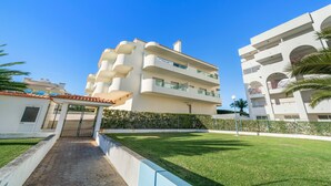 A multi-story hotel with balconies, a paved entrance, and a well-maintained lawn. - 1-Bedroom Apartment with Garden View, Shared Pool, Wi-Fi & Air Conditioning (Porches)