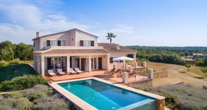 A two-story house with a swimming pool, outdoor seating, and a view of the surrounding landscape. - Sa Figuera – Extraordinary Villa with Mountain Views, Wi-Fi, and Air Conditioning (Illes Balears)