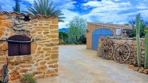 A stone building with a metal door and a large wheel. - Holiday Home 'S'altra Casa' with Private Pool, Wi-Fi & Air Conditioning (Illes Balears)