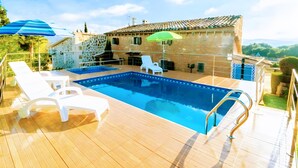 A swimming pool with lounge chairs, a wooden deck, and a stone building with a tiled roof. - Holiday Home 'S'altra Casa' with Private Pool, Wi-Fi & Air Conditioning (Illes Balears)