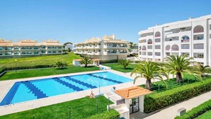 Un complex turístic amb piscina, edificis de diversos pisos i zones verdes ben cuidades.
