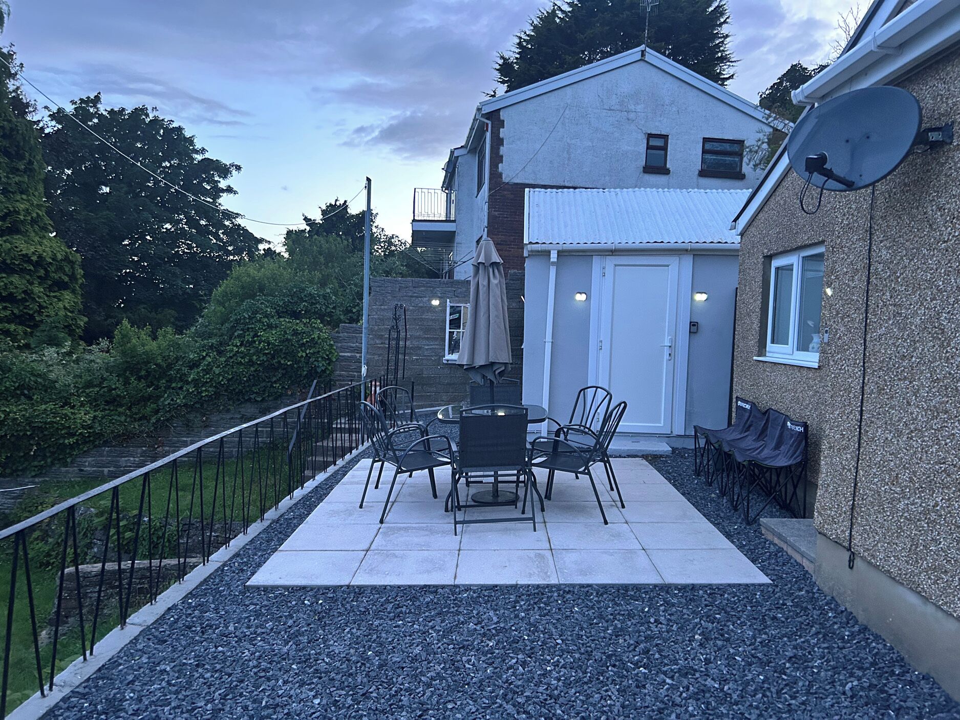 A patio with outdoor furniture, a white door, and a satellite dish.