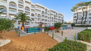 Un hôtel à plusieurs étages doté de balcons, d’une aire de jeux et d’espaces paysagers.