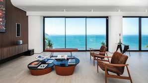 A modern interior with large windows, a seating area with a bench and chairs, and a wooden accent wall.