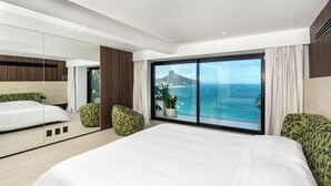 A modern bedroom with a large bed, a mirrored wardrobe, and a view of the ocean.