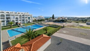 Um resort com piscina, alpendre coberto e vista para o mar.