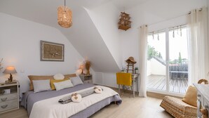 A bedroom with a bed, bedside tables, a chair, a window with curtains, and a view of the outside. - Apartment "Le clos du pont" with Lake View, Shared Pool and Wi-Fi (THEIX-NOYALO)