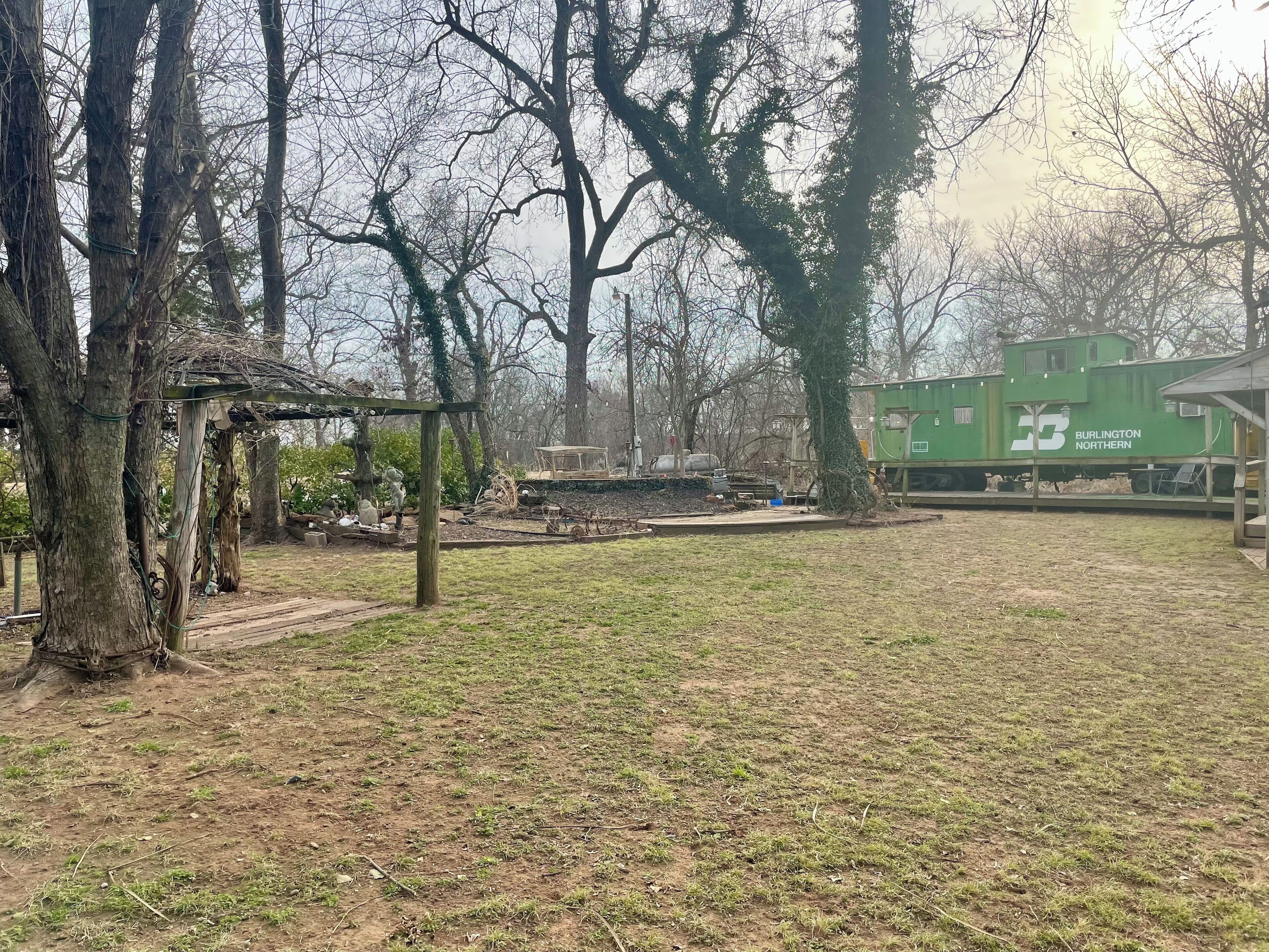 A park with trees, a gazebo, and a green train car labeled 'Burlington Northern'.