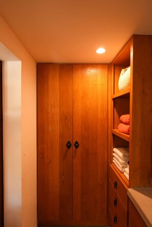 Ein Holzkleiderschrank mit zwei Türen und einem Fach mit gefalteten Handtüchern.