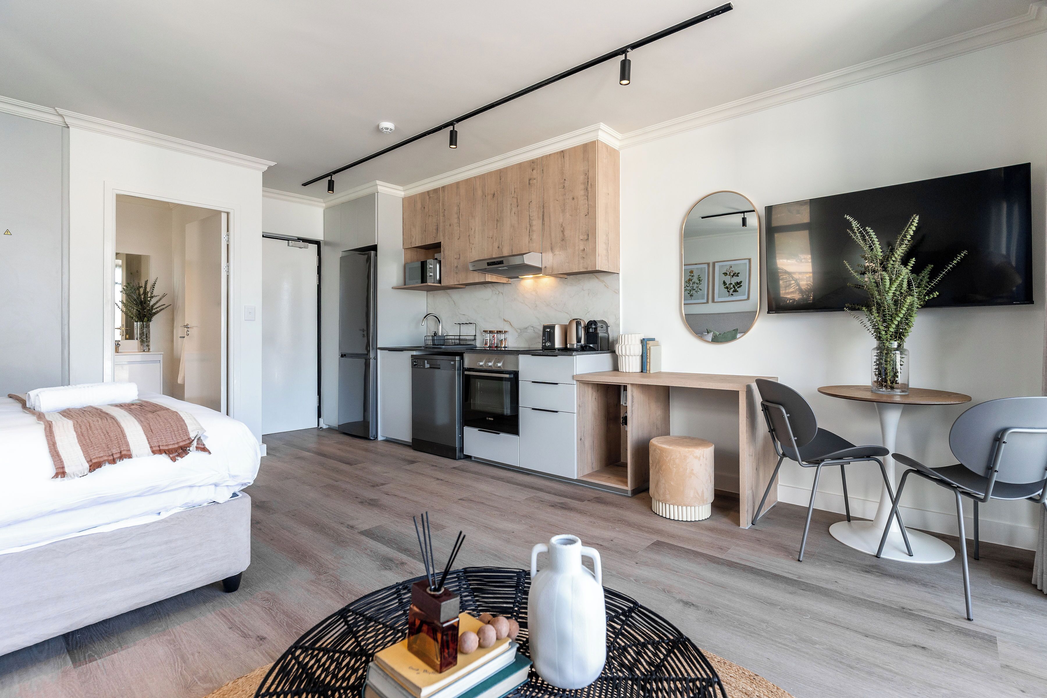 Eine moderne Wohnung mit Küchenzeile, Essbereich und Wohnraum mit Sofa und Couchtisch.