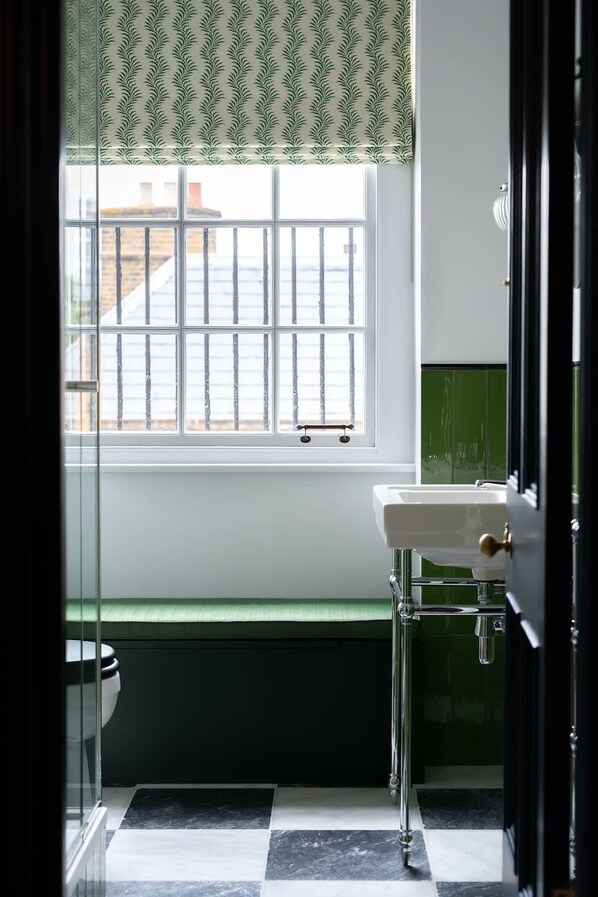 Une salle de bain avec une fenêtre, un lavabo et des toilettes.