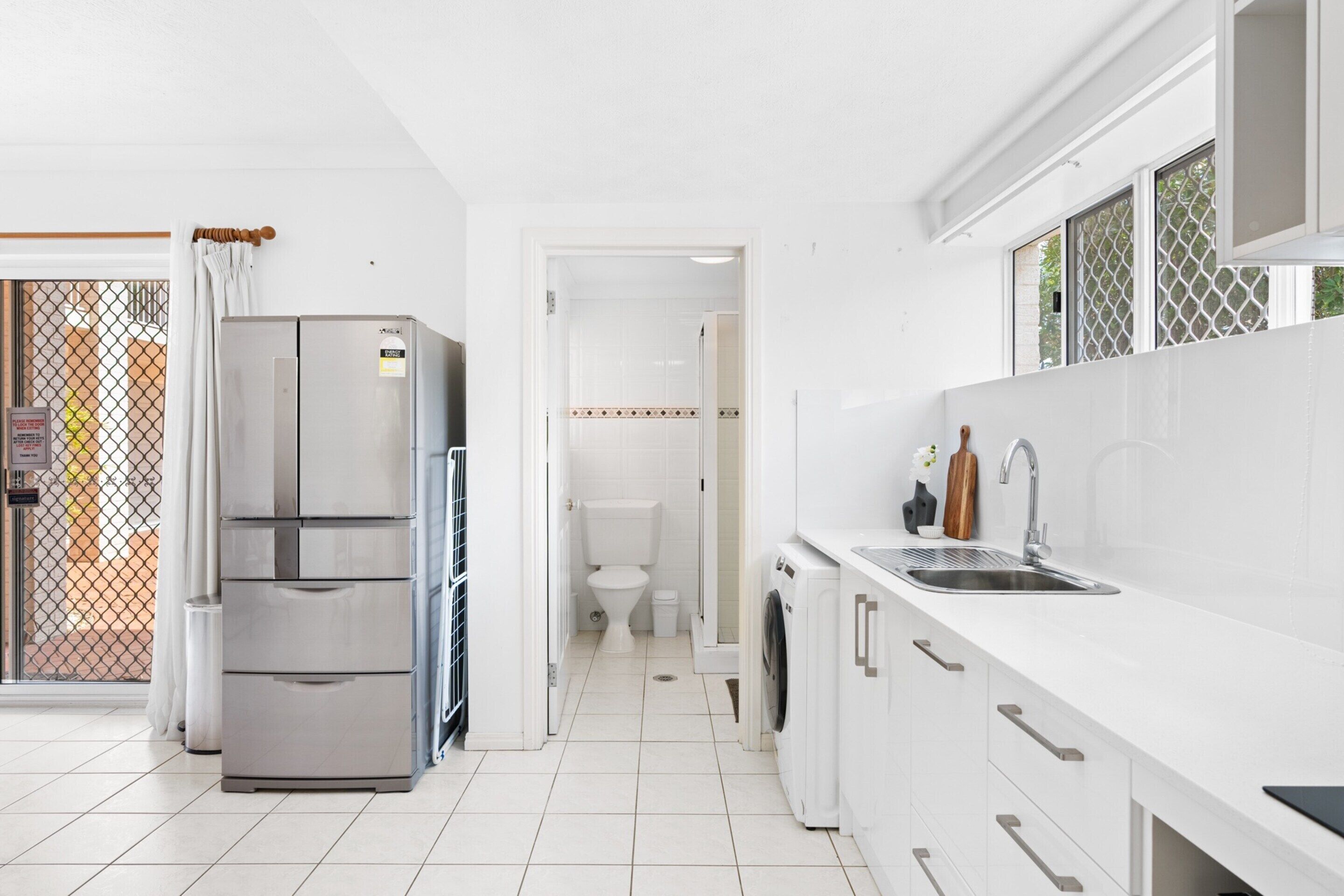 A modern kitchen with a stainless steel refrigerator, a built-in oven, and a sink.
