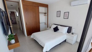 Ein Schlafzimmer mit Bett, Nachttischen, einem Fernseher und einem Kleiderschrank.