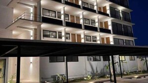 Ein mehrstöckiges Hotel mit Balkonen, großen Fenstern und einem überdachten Eingangsbereich.