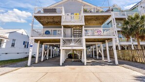 A multi-story building with a central entrance, balconies, and a wooden deck area. - Top Floor Canal View TownHome - 3 BDRM Sleeps 8 with Linens (Carolina Beach)