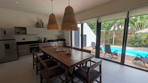 A modern kitchen with a dining area, a pool, and a view of the outdoors. - Luxury 4 Bedroom Villa, Private Pool Near to restaurants, cafes, bars & beach! (Tulum)