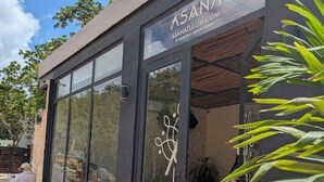 A modern building with large glass windows and a sign reading "ASANA NATULUM COM BY MARECOCO DESIGN-HOMES". - Luxury 4 Bedroom Villa, Private Pool Near to restaurants, cafes, bars & beach! (Tulum)