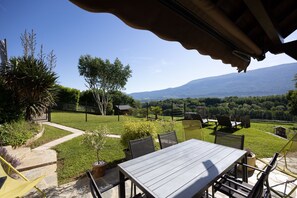 A patio with a table and chairs, a stone pathway, and a view of a mountain. - Gîte le rêve: Between Lake and Mountains, Near Aix-les-Bains and Savoie Grand Revard (Viviers du Lac)