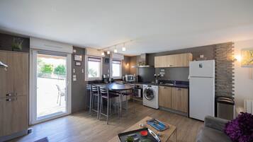 A compact kitchen with a dining area, built-in appliances, and a sliding glass door leading to an outdoor space.