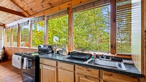 Une cuisine avec des meubles de rangement en bois, une cuisinière et un évier.
