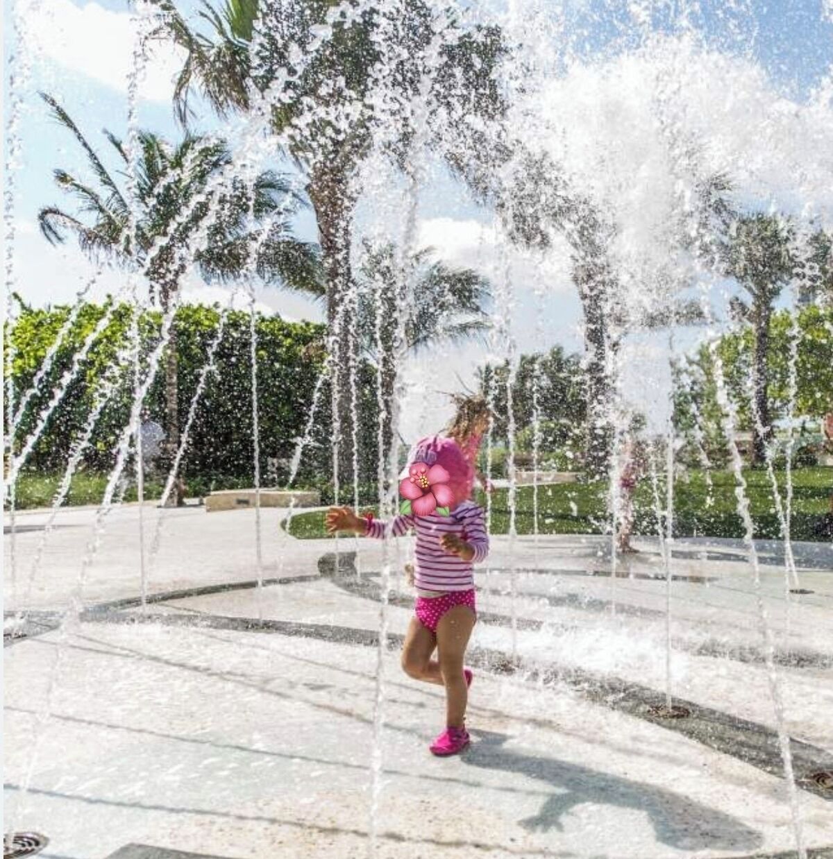 Niño jugando en una zona de fuentes con varios chorros de agua.