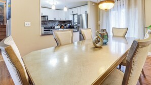 A dining area with a large wooden table, cushioned chairs, and a chandelier. - 3 Mi to South Park: Quiet Pittsburgh Area Getaway (Pittsburgh)