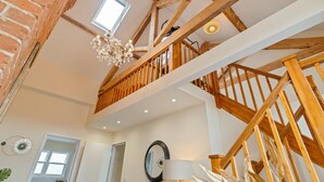 A spacious loft-style room with exposed wooden beams, a skylight, and a chandelier. - Unique Rooftop Retreat | City View | Sleeps 4 (Kent)