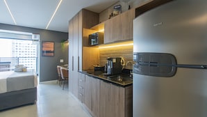 A modern kitchen with wooden cabinets, a stainless steel refrigerator, and a built-in microwave. - Elegance and Comfort - Close to Allianz Parque Sp-p2202b (São Paulo)