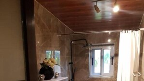 A compact bathroom with a toilet, a shower, and a small window. - Home Stay In Accra, Travellers With Kids Are Welcomed. 5 mins Walk Away To Beach (Accra)