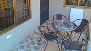 A small, enclosed balcony with a tiled floor, a table with chairs, and a door. - Home Stay In Accra, Travellers With Kids Are Welcomed. 5 mins Walk Away To Beach (Accra)