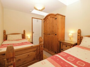 A bedroom with two wooden beds, a wardrobe, and a skylight. - Orchard Cottage (Gloucester)