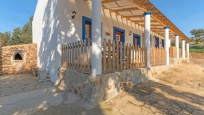 Un bâtiment avec des fondations en pierre, des colonnes en bois et une clôture en bois.