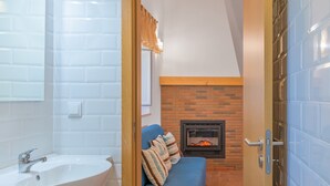 Une salle de bain avec un lavabo, un miroir et des murs recouverts de carreaux blancs.
