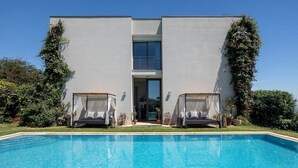 Un bâtiment moderne à deux étages, avec une piscine située devant.