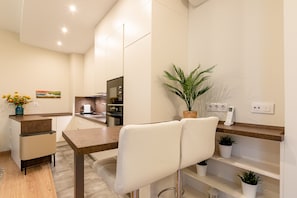 A modern kitchen with a dining area, a small table, and chairs. - Fasquel Center Apartment (Sevilla)