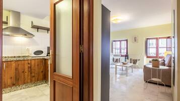 Una cocina con armarios de madera, microondas y una campana extractora de acero inoxidable.