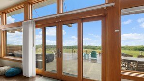 A spacious room with large sliding glass doors leading to an outdoor patio area. - Oceanfront Escape in Westport, WA (Westport)