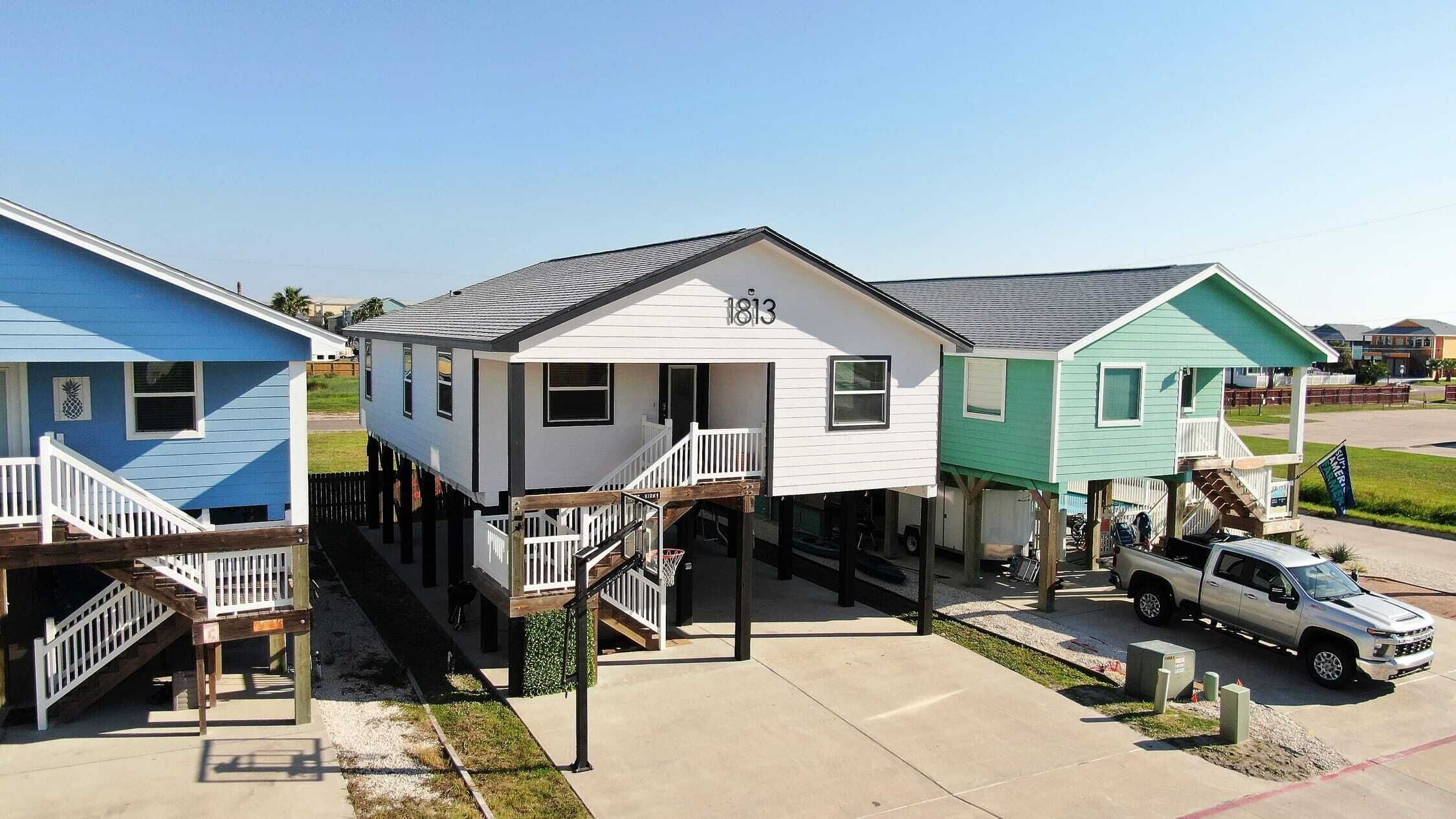 A row of waterfront homes with external staircases leading to the ground level.