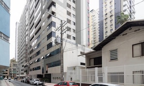 A multi-story residential building with balconies, a gated entrance, and parked cars on the street. - Apt Steps From the Beach in BC Crt0032 (Balneário Camboriú)