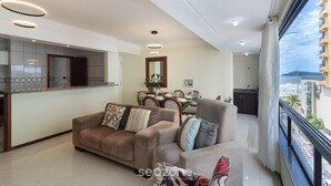 Ein modernes Wohnzimmer mit Sofa, Sessel und Essbereich.