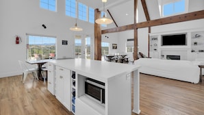 A spacious kitchen with a large island, wooden beams, and a fireplace. - “Country Living” Magazine Home, 5 min To Wineries, Resort Pool. (Temecula)