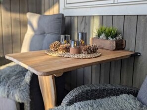 A wooden table with a woven placemat, pine cones, and candles. - Mountain cabin with jacuzzi at Forollhogna - sleeps 12, 1.5 hours from Trondheim (Trøndelag)