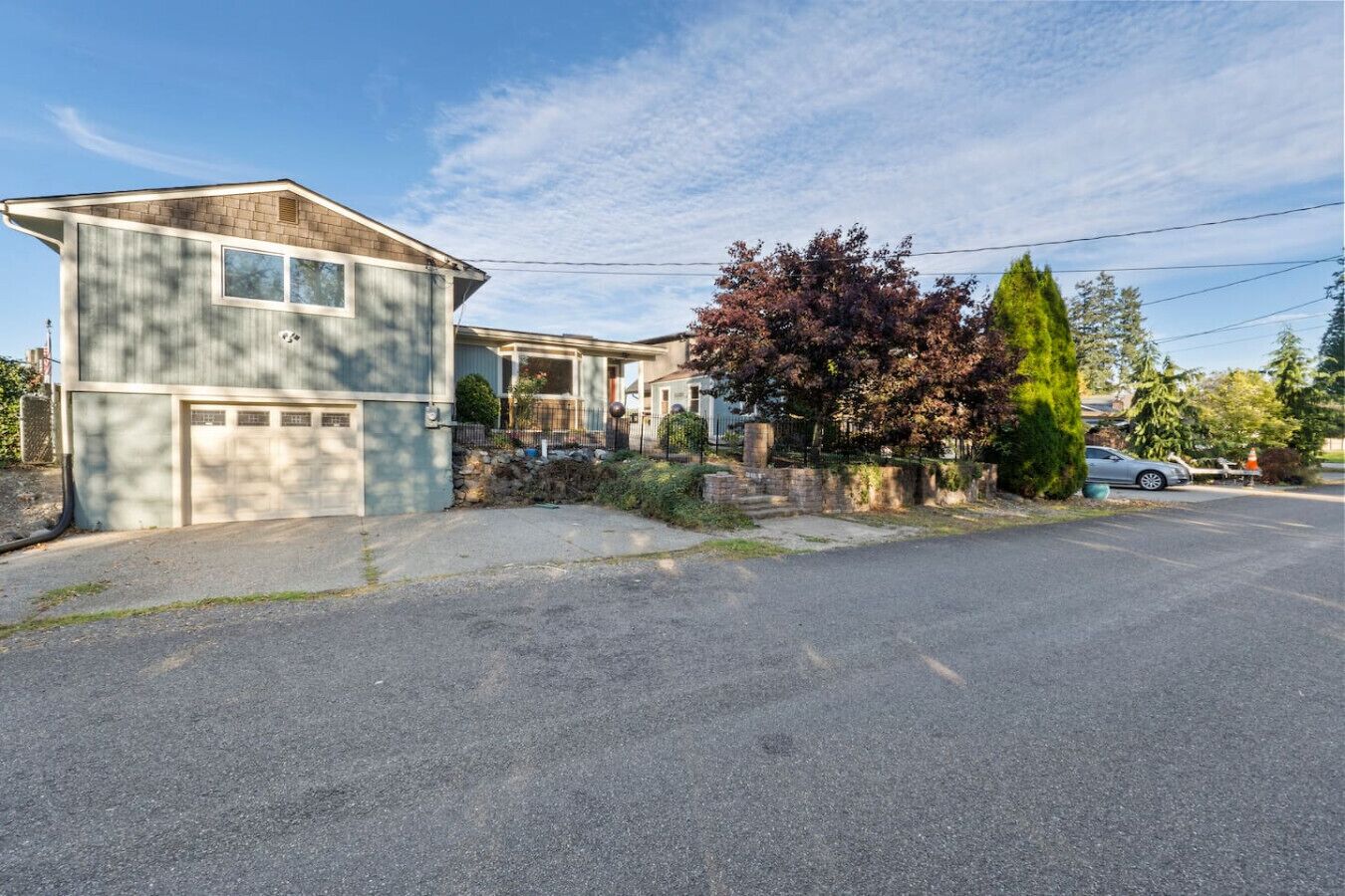 A two-story house with a garage, a driveway, and a well-maintained lawn.