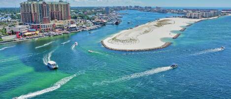 A coastal hotel with a marina, sandy beach, and clear blue waters.
