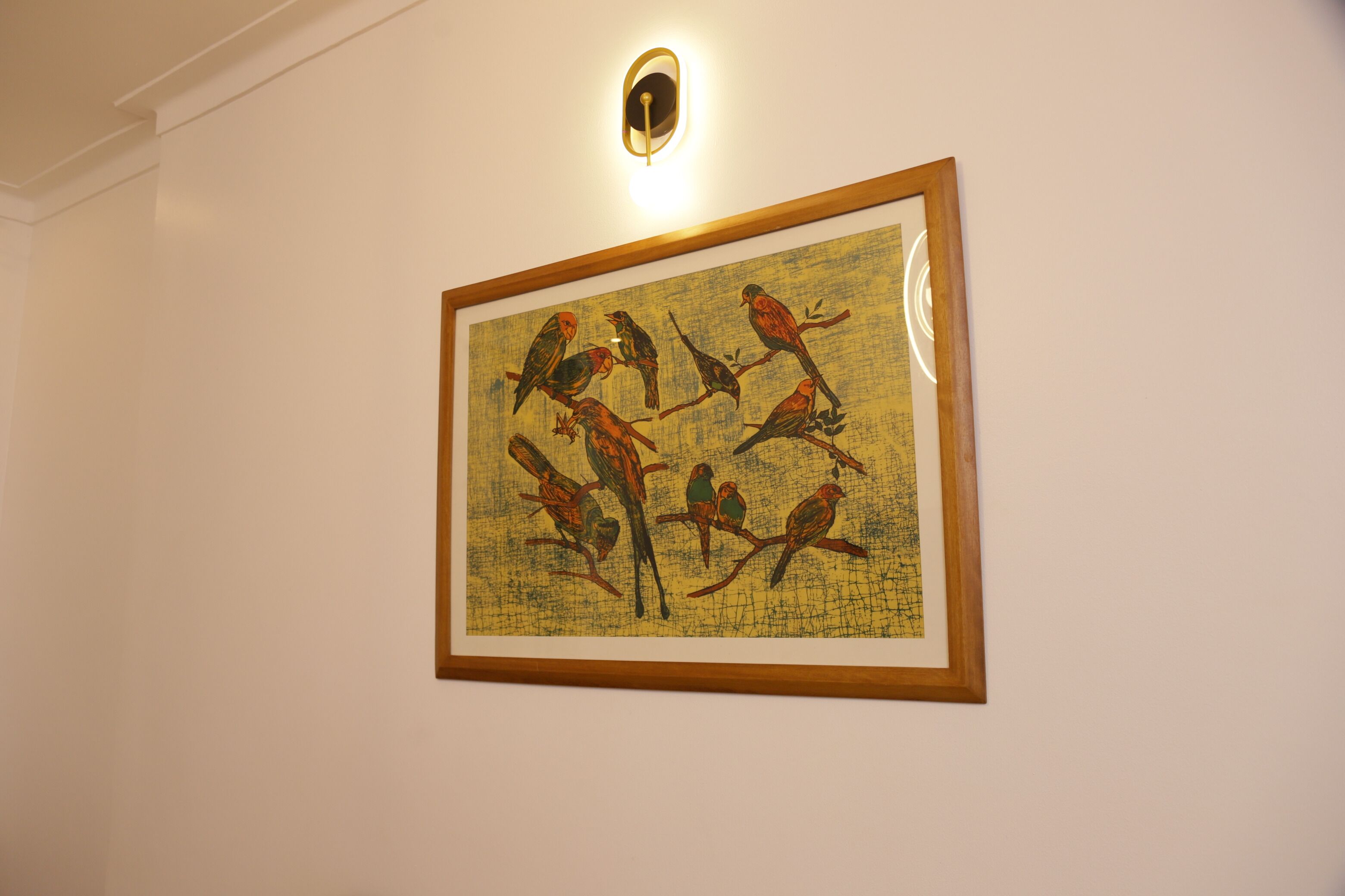 A framed artwork of birds on a wall.